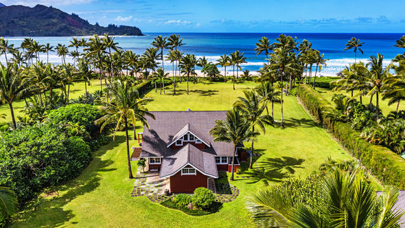 The Red House is beachfront at Hanalei Bay and includes a four-bedroom main house and a one-bedroom guesthouse.